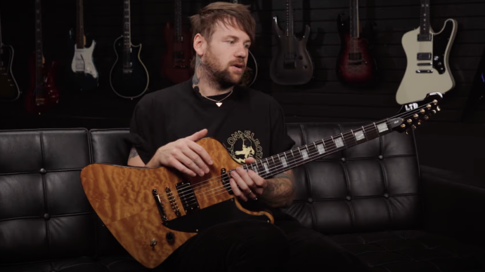 Caleb Shomo writing music with acoustic guitar