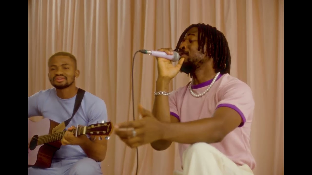 Johnny Drille performing with acoustic guitar