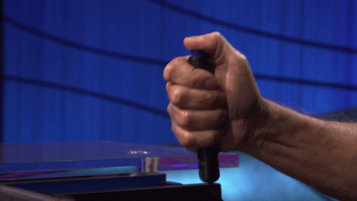 Jeopardy! contestants at their podiums with buzzers