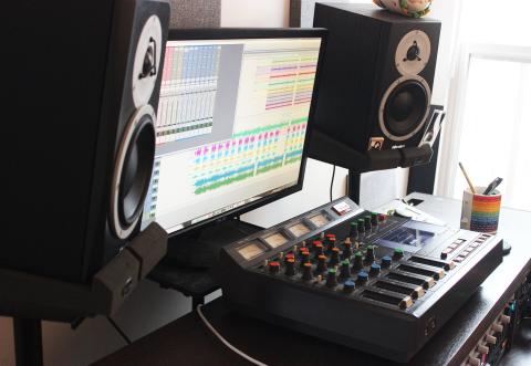 Independent artist working in home recording studio with equipment