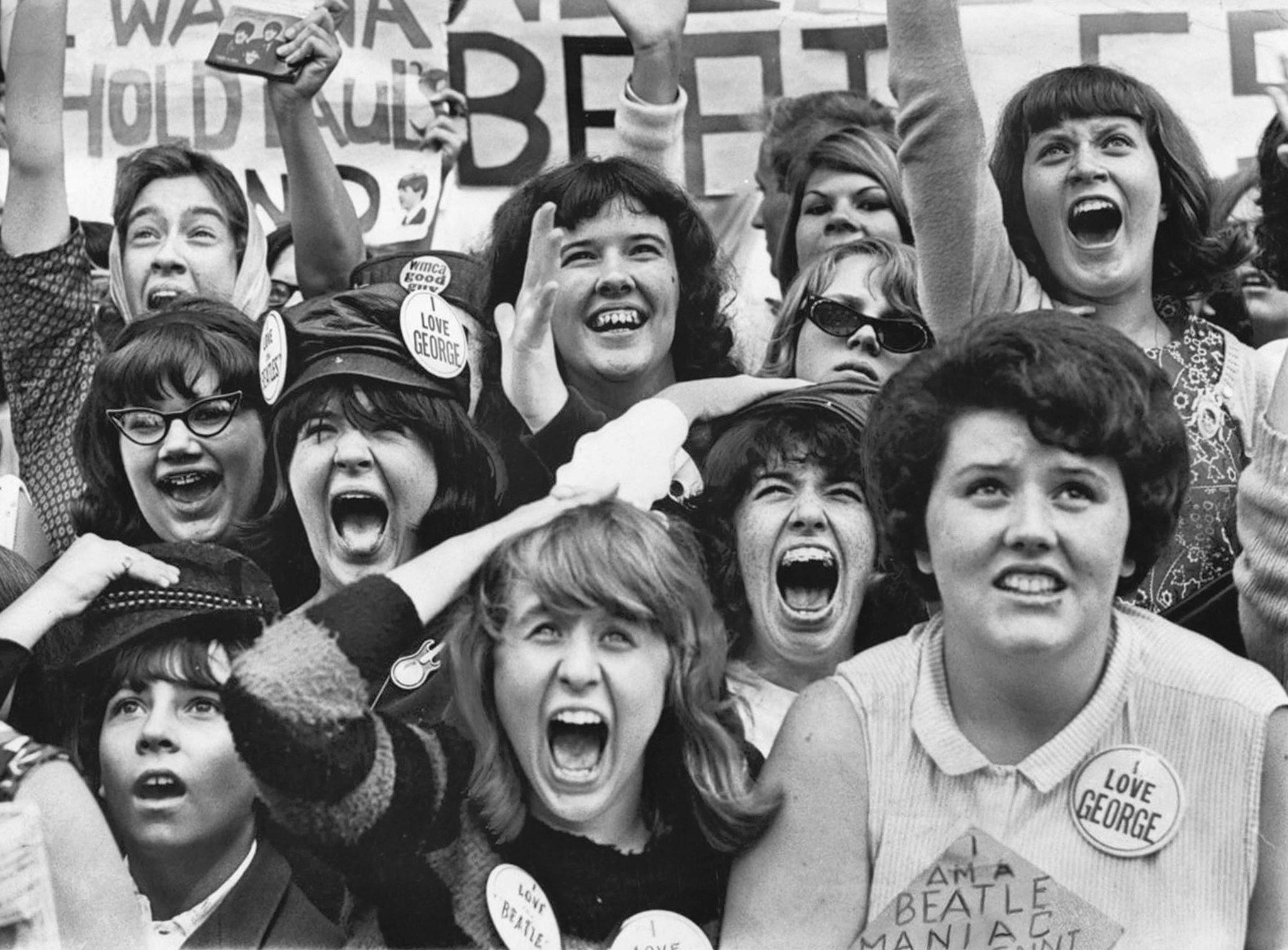 The Beatles performing to massive crowds during Beatlemania