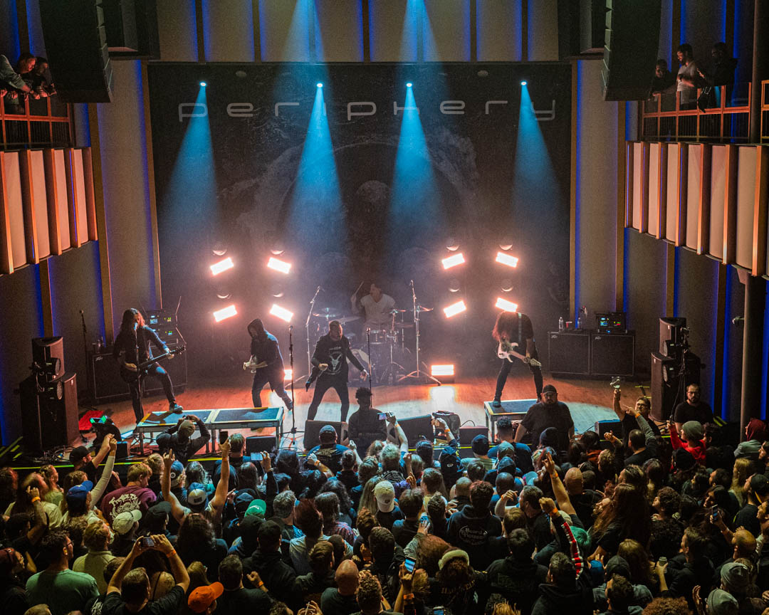 Periphery band performing on stage with lighting