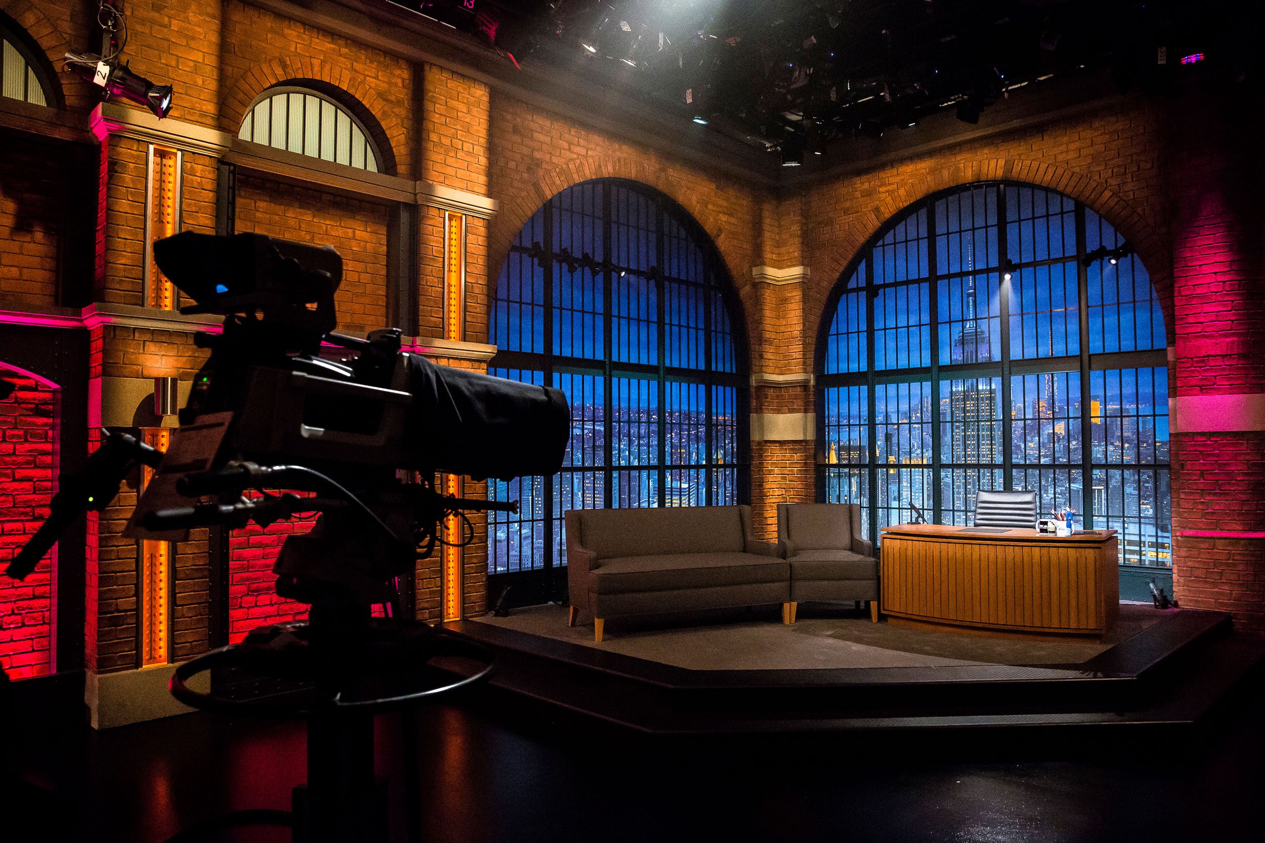 Modern television talk show studio with desk and chairs