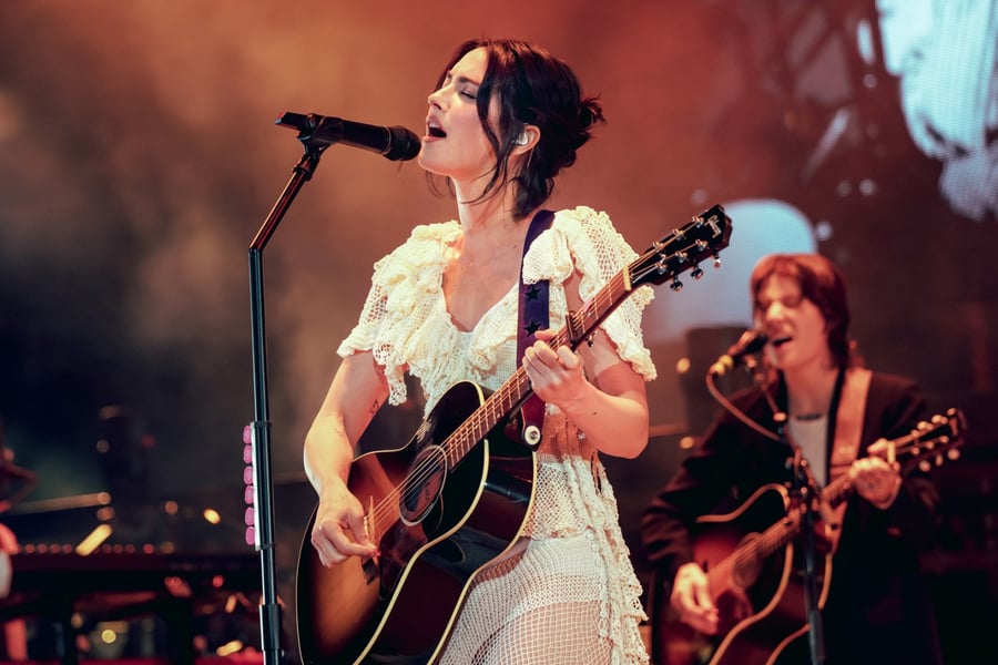 Gracie Abrams performing on stage with guitar