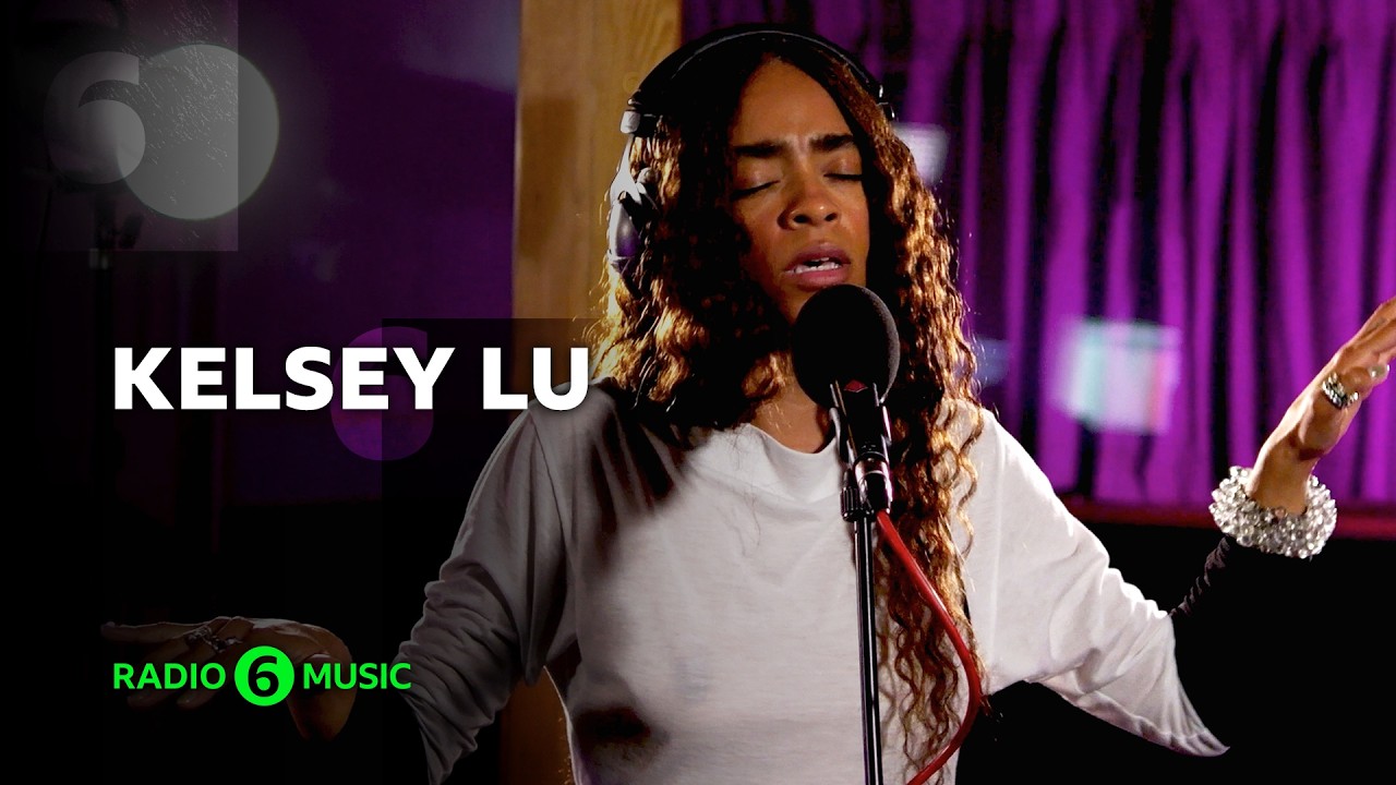 Kelsey Lu performing live on stage with atmospheric lighting