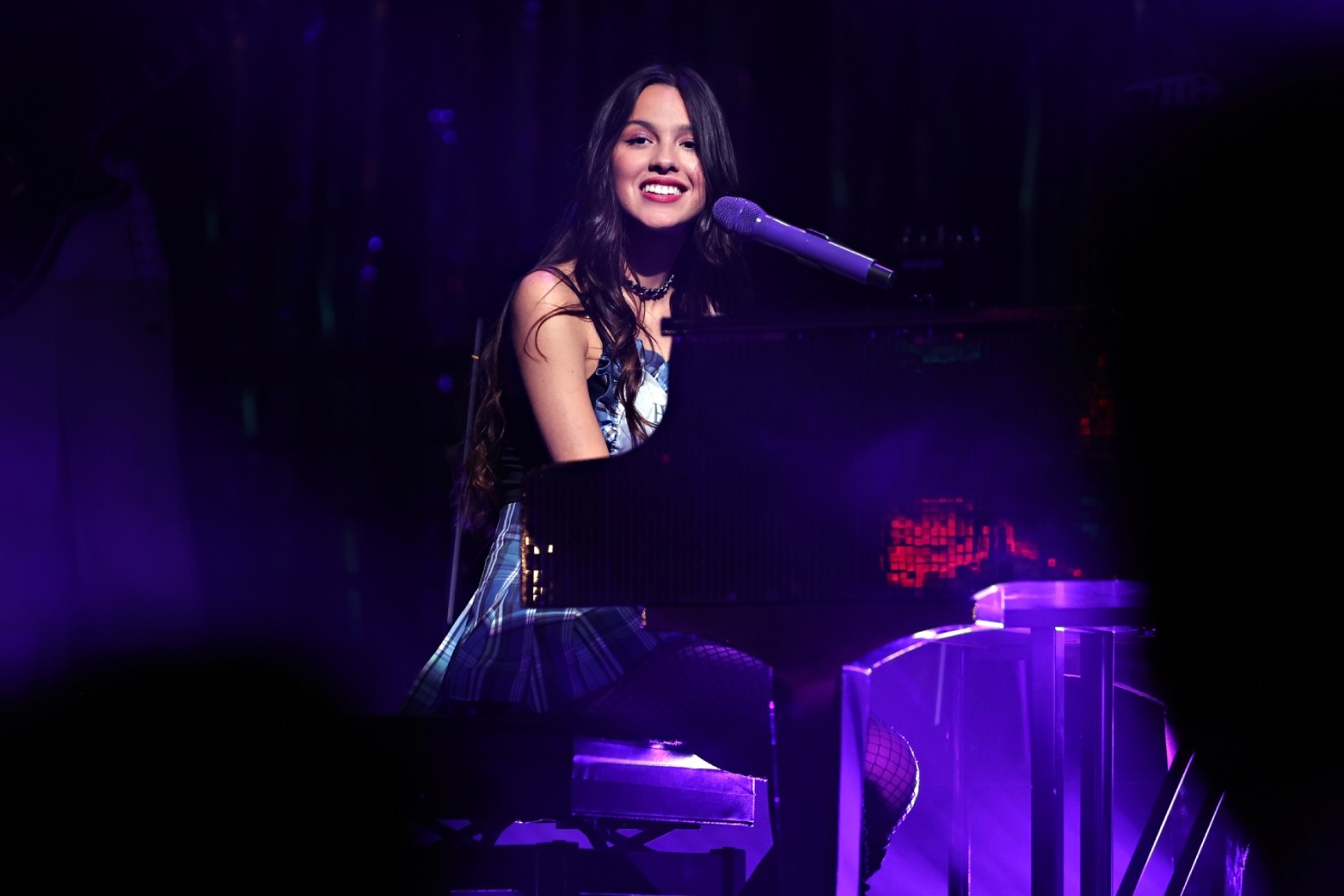 Olivia Rodrigo singing live on stage with microphone