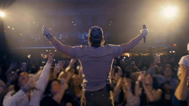 Tucker Wetmore performing on stage at a country music venue