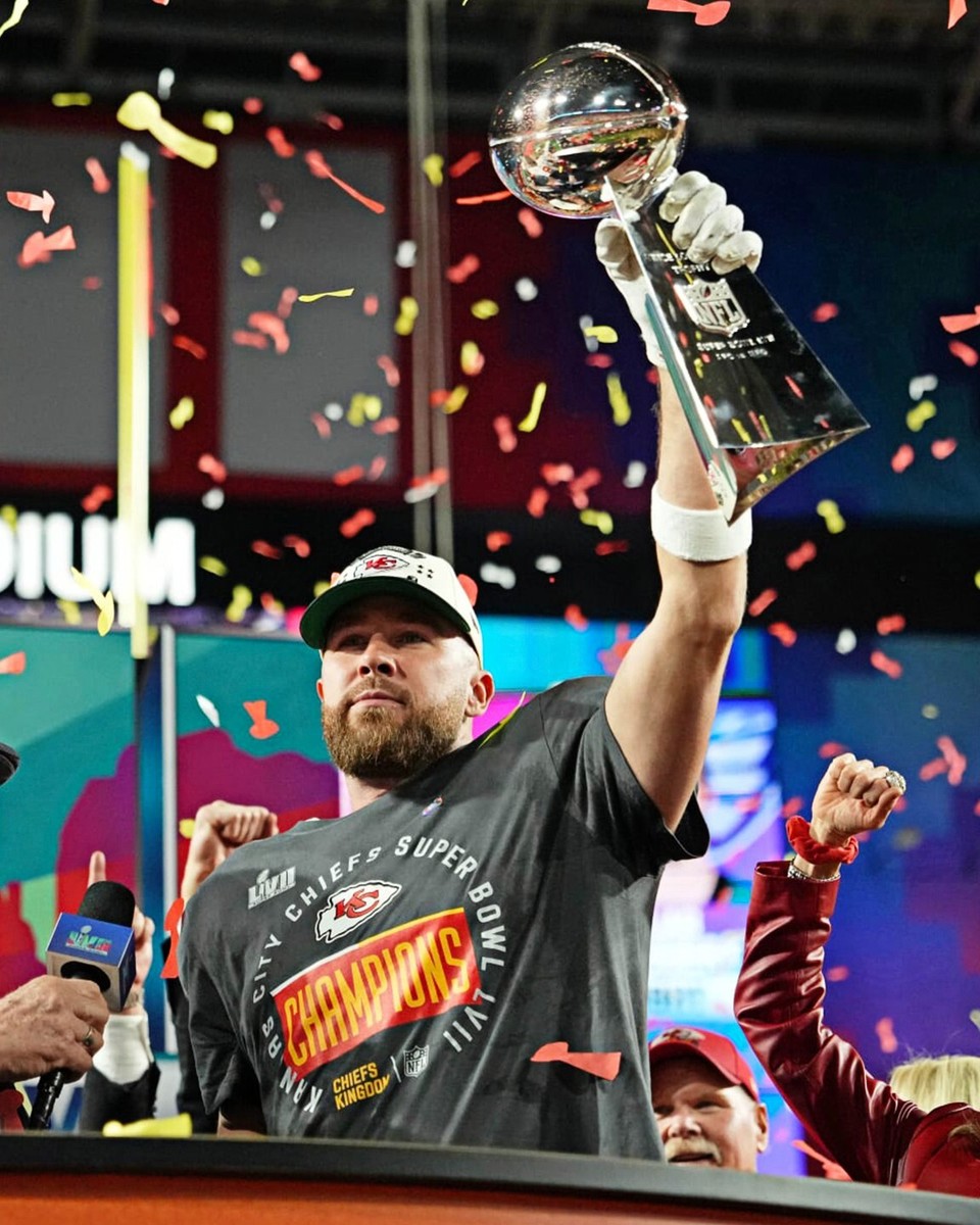 Travis Kelce holding the Lombardi Trophy after a Super Bowl victory