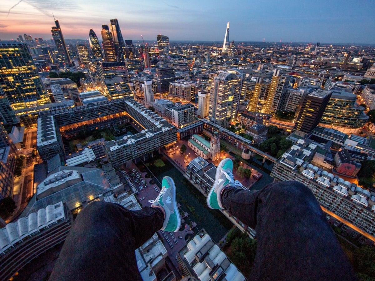 Urban rooftoppers photographing city skyline from skyscraper height
